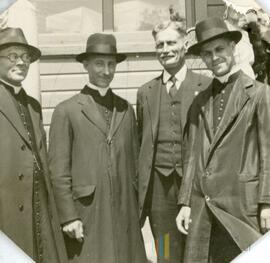 Quatre hommes dont trois portant un chapeau