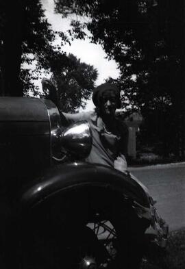 Une femme inconnue assise sur un pare-choc en avant d'une voiture