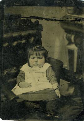 Petite fille posant assise sur un fauteuil