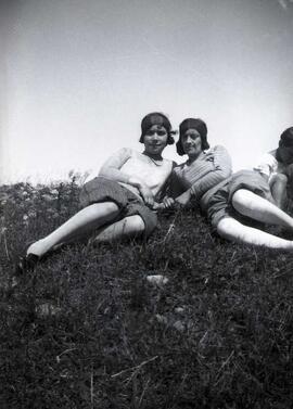 Deux femmes inconnues avec bandeaux sur la tête assises dans un champ