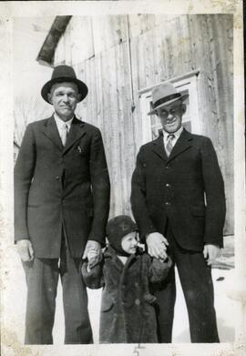 Dona Germain et Saskett Kingsborough avec un enfant devant un bâtiment