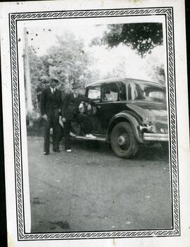 Emmett Henderson et un homme non identifié à côté d’une voiture