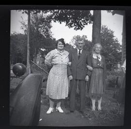 Saskett Kingsborough avec sa femme et une autre femme non identifiée à l’extérieur