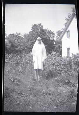 Iola Kingsborough portant une robe et un voile blancs à l'extérieur