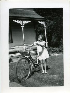 Carol Kingsborough à côté d’une bicyclette devant une maison
