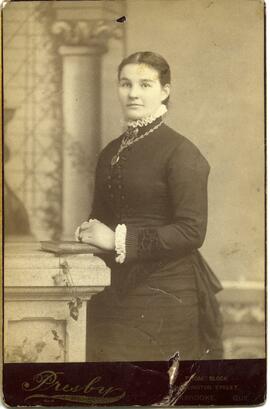 Portrait d’une femme non identifiée devant un décor
