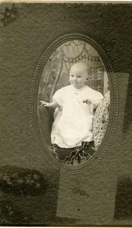 Portrait d’un bébé non identifié assis sur une chaise