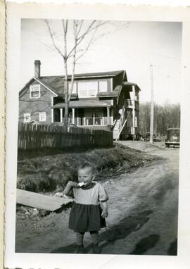Un enfant non identifié devant une maison