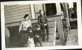 Quatre enfants de John Kingsbury et un chien dans les escaliers d’une maison