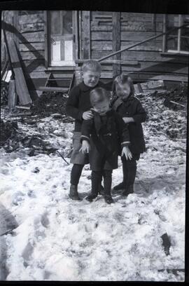 Alice, Everett et Clifford Kingsborough devant une maison dans la neige
