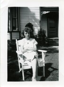 La femme de Clarence Kingsborough assise devant une maison