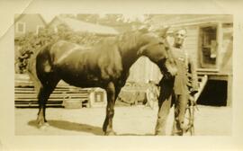 Un homme non identifié à côté d’un cheval