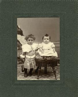 Photographie de deux jeunes enfants (bébé et petite fille à la sacoche)