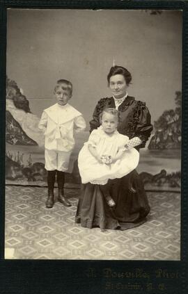 Photographie de deux enfants et d’une femme assise