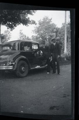 Emmett Henderson et un homme non identifié à côté d’une voiture
