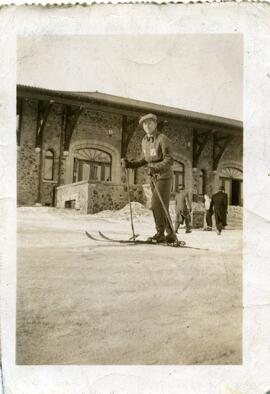Un homme en skis devant un bâtiment