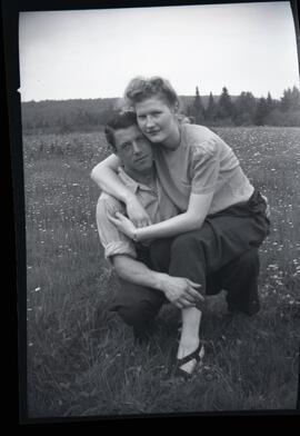 Iola Kingsborough assise sur le genou d'un homme à l'extérieur