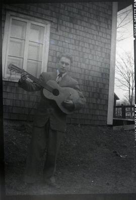 Malcolm Kingsborough tenant une guitare à l'extérieur