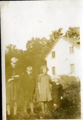 Quatre enfants de Saskett Kingsborough devant une maison
