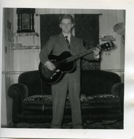 Malcolm Kingsborough jouant de la guitare dans une maison