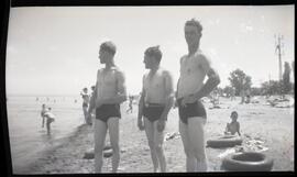 Harold Ross avec deux hommes non identifiés en maillot de bain à la plage