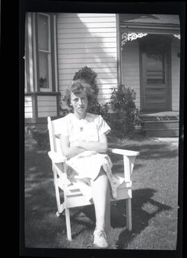 La femme de Clarence Kingsborough assise devant une maison