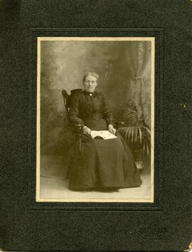 Portrait d’une femme assise tenant un livre