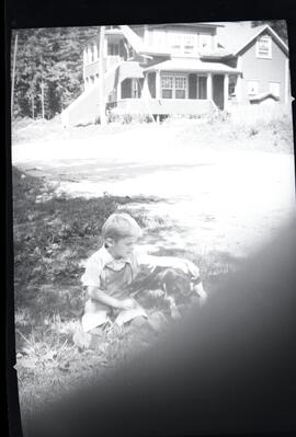 Malcolm Kingsborough lorsqu’il était enfant avec un chien à l’extérieur