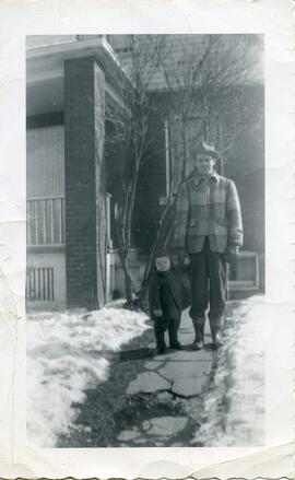 Harold Ross et son fils Everett devant une maison en hiver