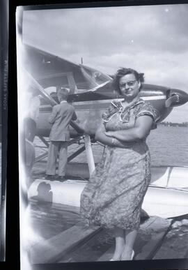 Une femme non identifiée devant un hydravion
