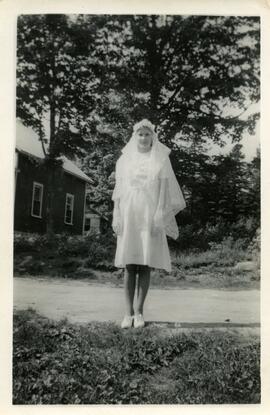 Iola Kingsborough portant une robe et un voile blancs à l’extérieur