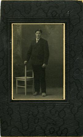 Portrait d’un homme non identifié à côté d’une chaise