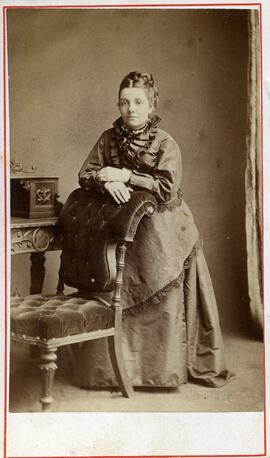Portrait d’une femme non identifiée appuyé sur un fauteuil