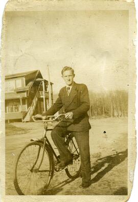 Lloyd Kingsborough sur une bicyclette devant une maison