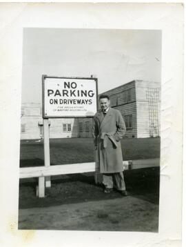 Un homme devant un panneau de "No parking"