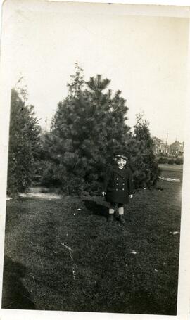 Un enfant non identifié devant un arbre