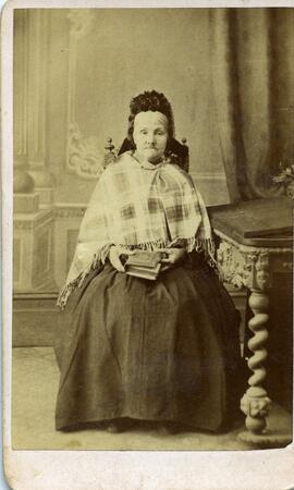 Portrait d’une femme non identifiée assise tenant un livre