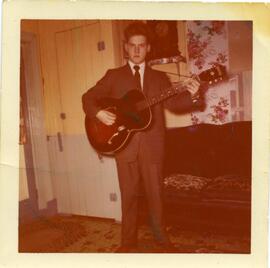 Malcolm Kingsborough jouant de la guitare dans une maison