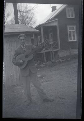 Malcolm Kingsborough tenant une guitare à l'extérieur