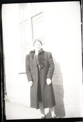 Une femme non identifiée devant un bâtiment